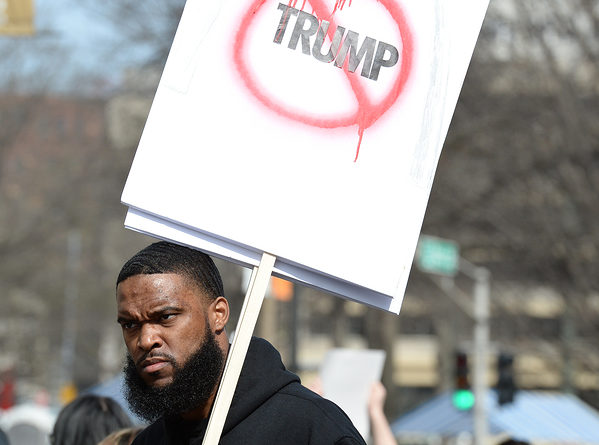 Protester holds signs outside a Donald Trump rally at the Peabody Opera House in Downtown Saint Louis