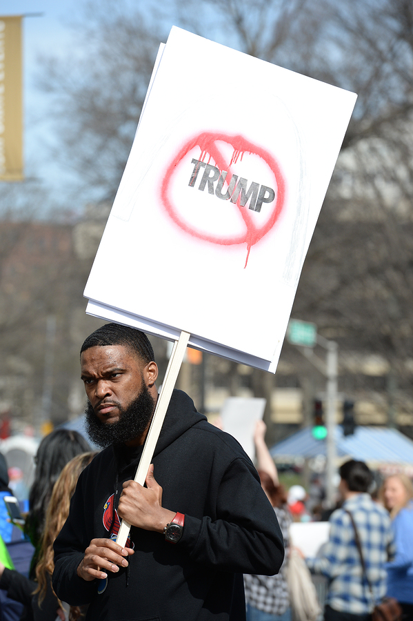Protester holds signs outside a Donald Trump rally at the Peabody Opera House in Downtown Saint Louis
